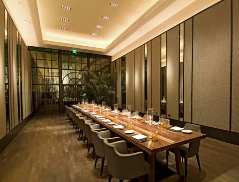 Long private dining room with wood flooring and glazed partitions