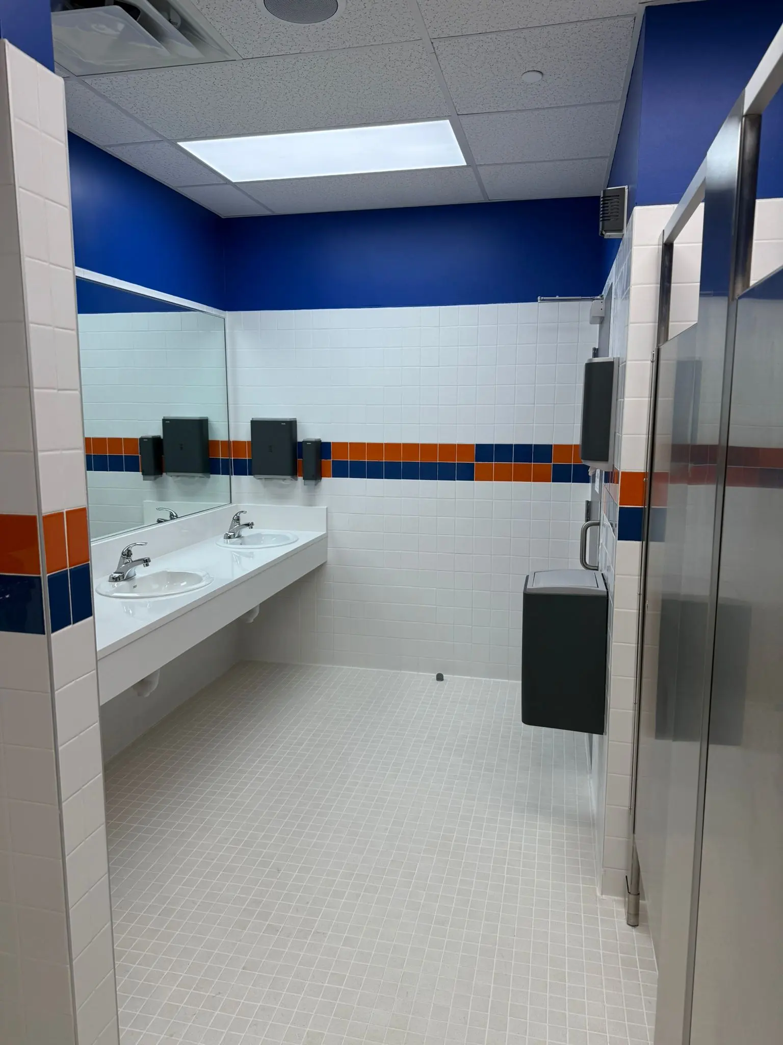Completed school restroom with blue and orange finish details