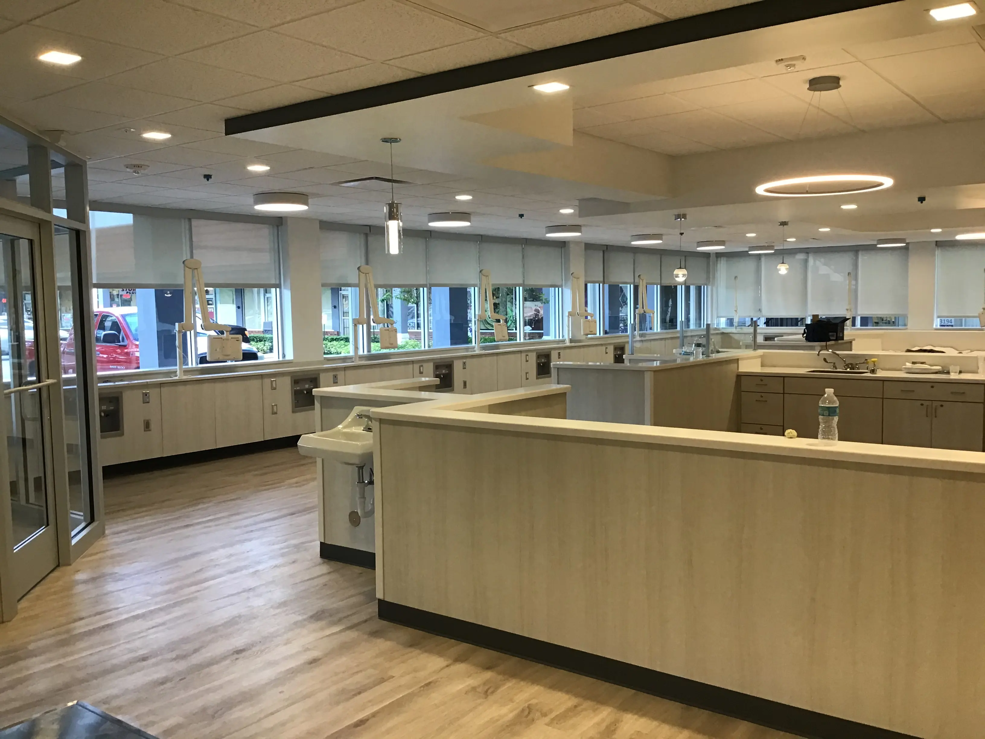 Open clinical work area with window-wall casework and overhead service arms