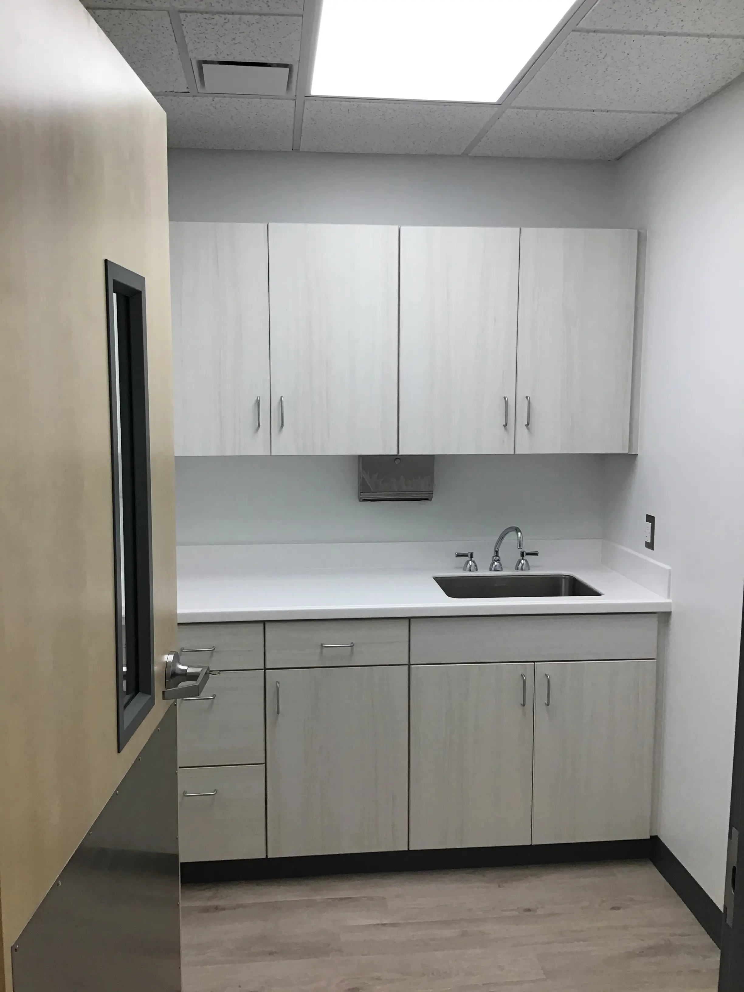 Support room with upper and lower casework, sink, and clean finishes