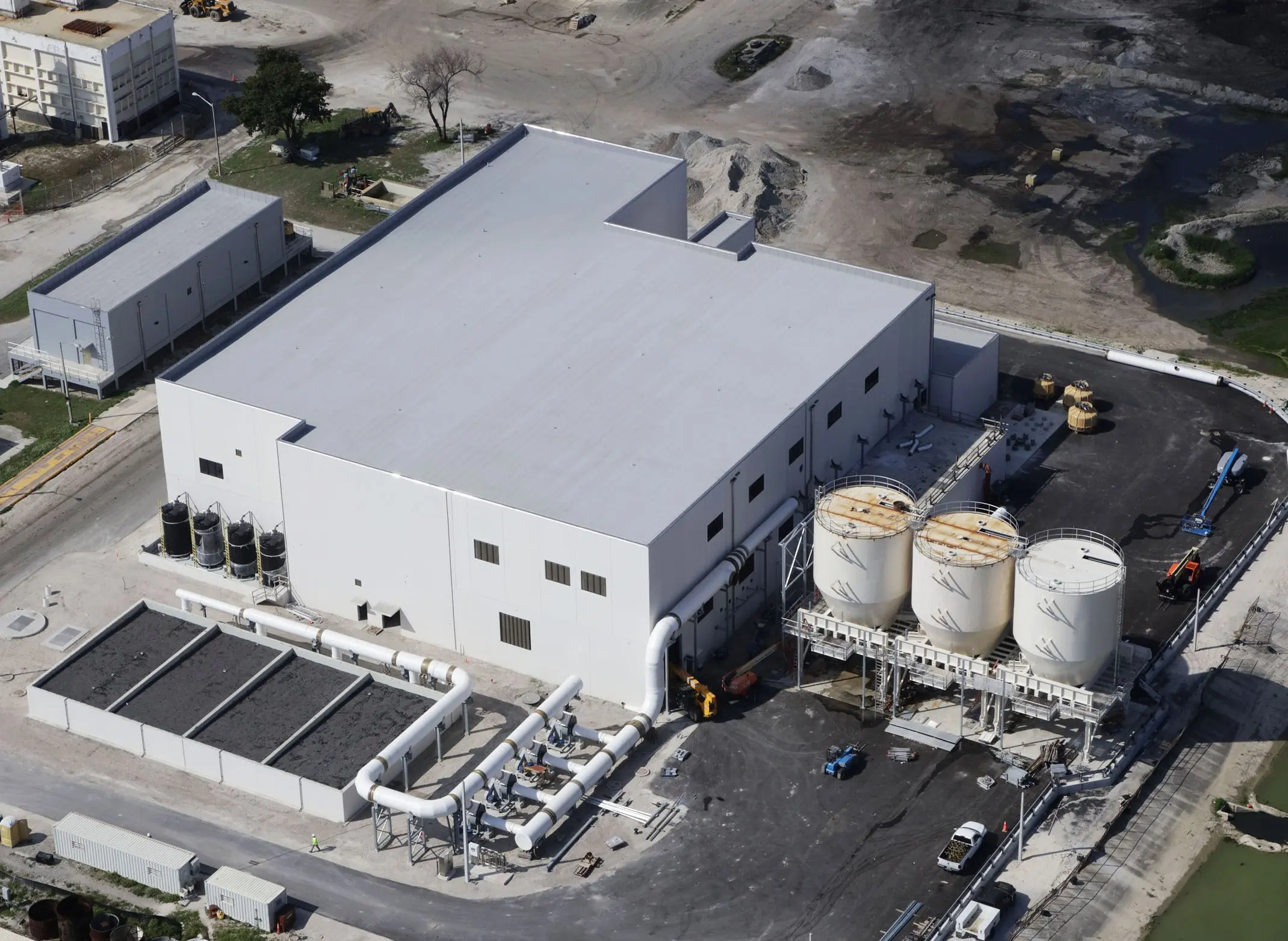 Industrial facility exterior with steel structure, process piping, and site infrastructure